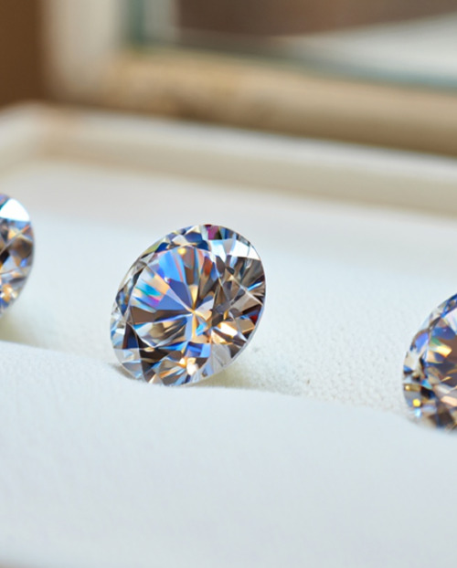 Cut round diamonds sat on cream cushion