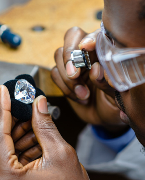 Man looking at a cut diamond with a loupe